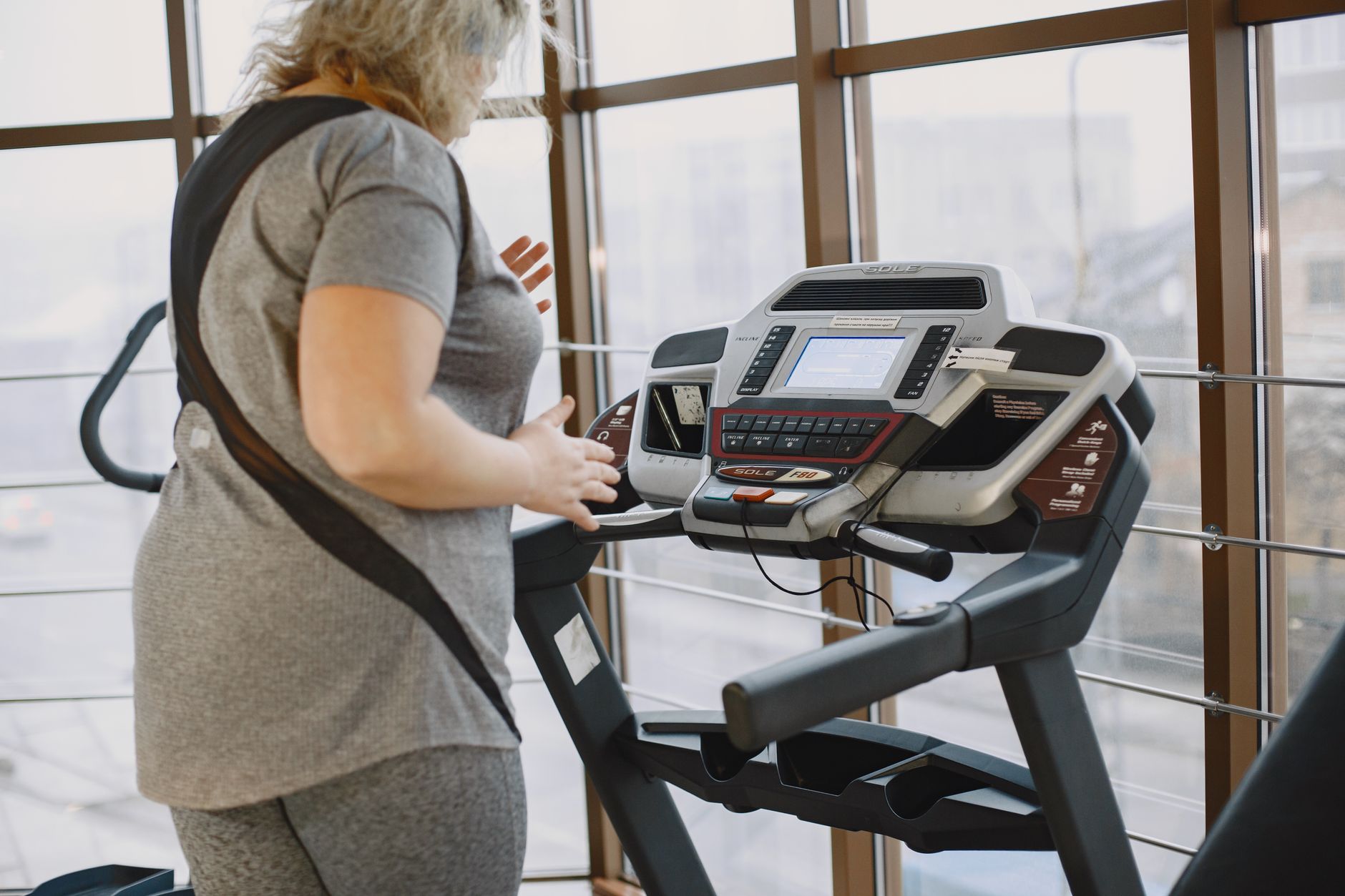gym technician inspecting treadmill gym technician inspecting treadmill