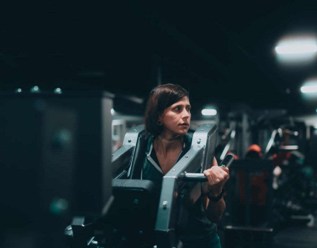 A woman intensely working out on a machine in a modern gym, showcasing determination and fitness.