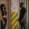 Side view of woman and black man in protective masks looking at each other while standing at distance