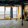 A modern gym with equipment, punching bags, and open space for workouts.